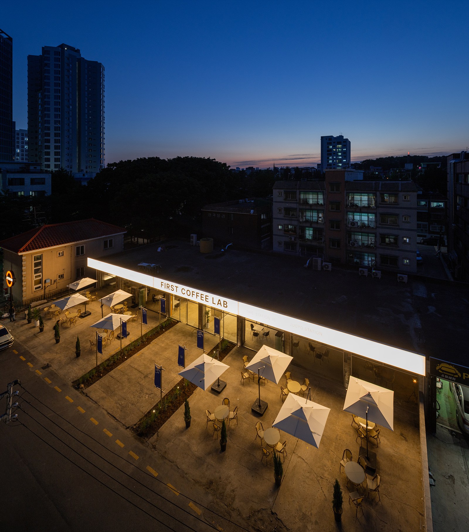 테라스와 긴 캐노피가 함께 보이는 주교스테이션 야간 조감
