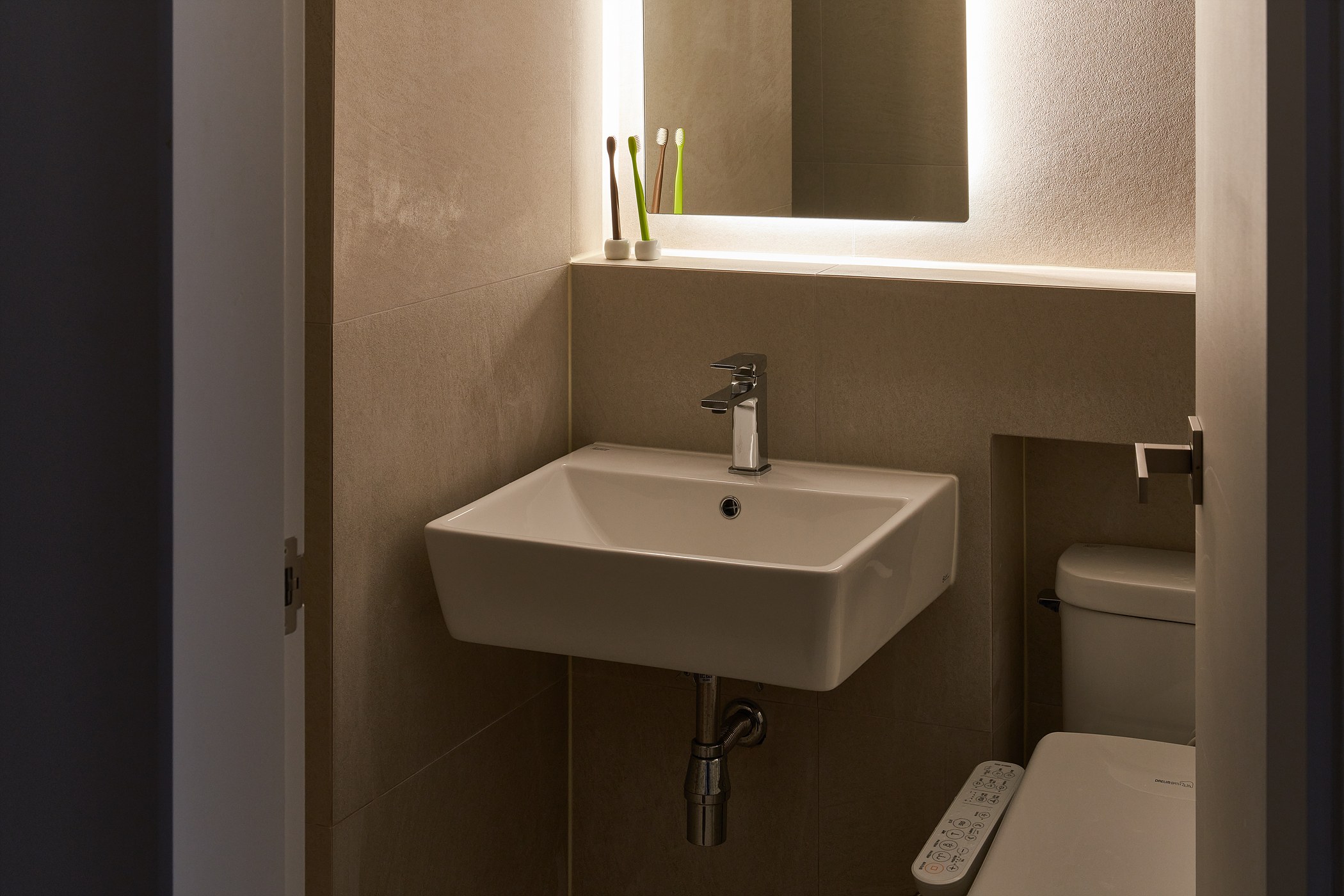 Compact bathroom composed with grey tile and concealed light