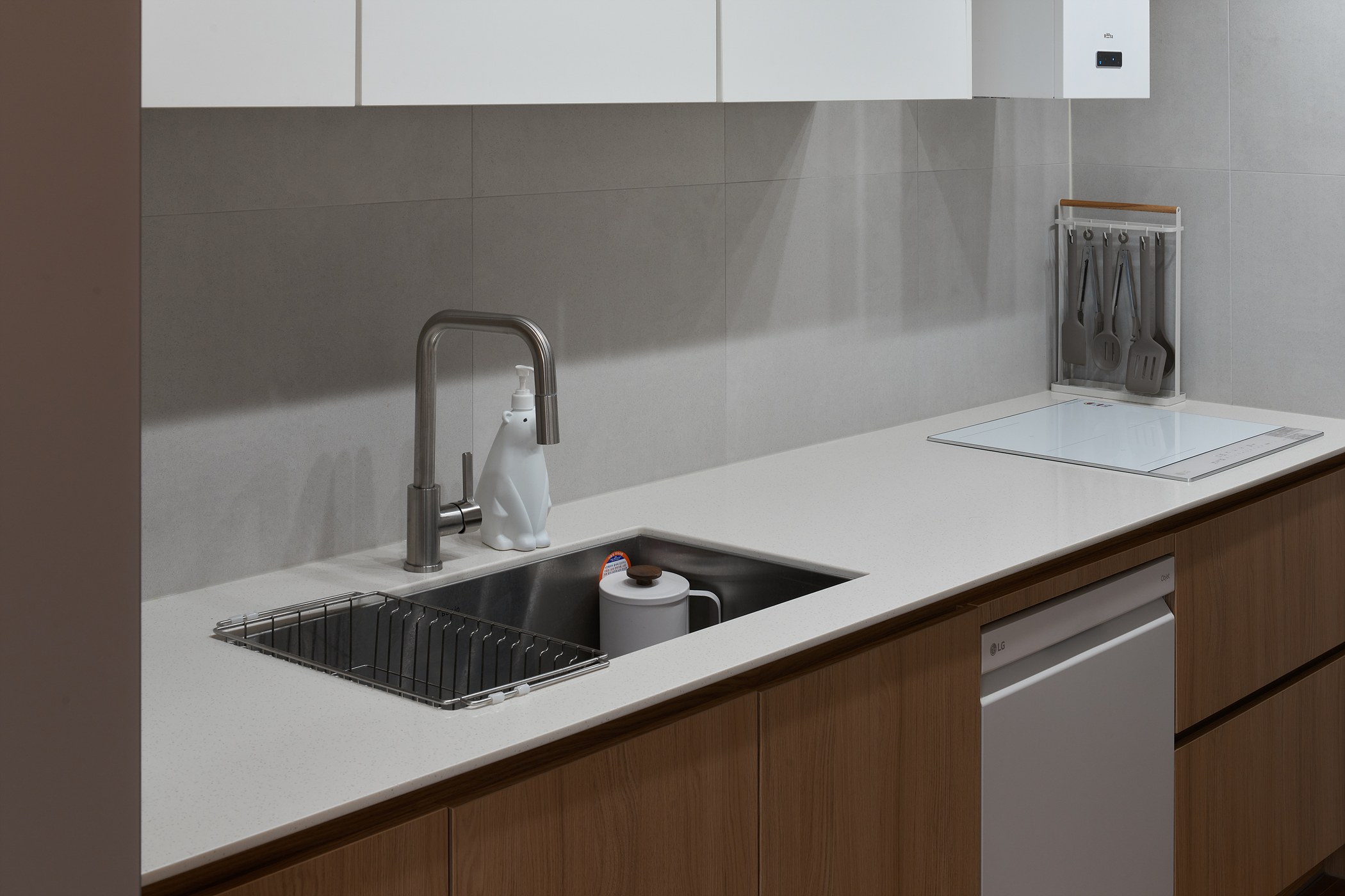 Kitchen detail where a white worktop meets timber cabinetry