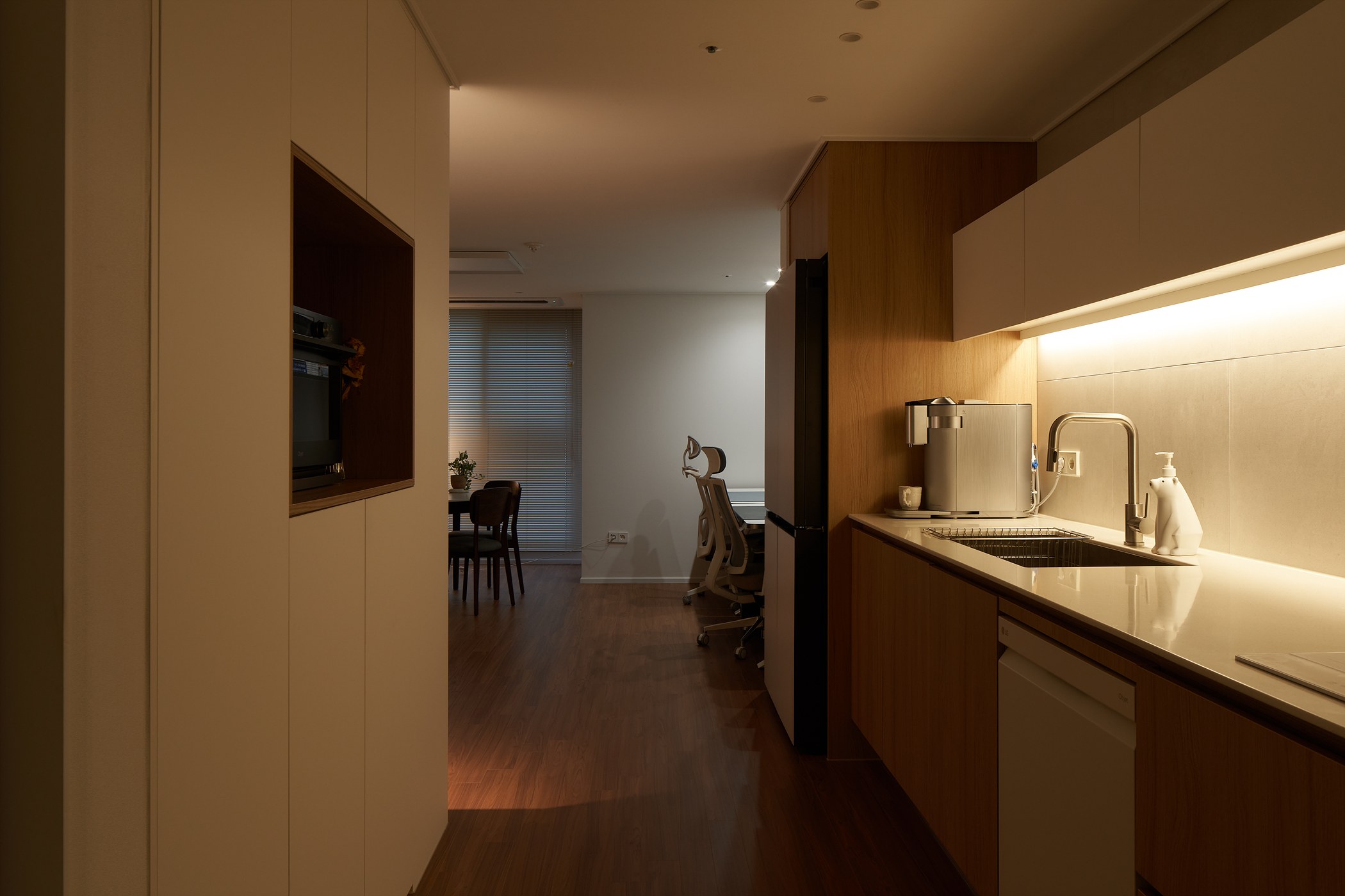 Warm kitchen light extending towards the dining area at night