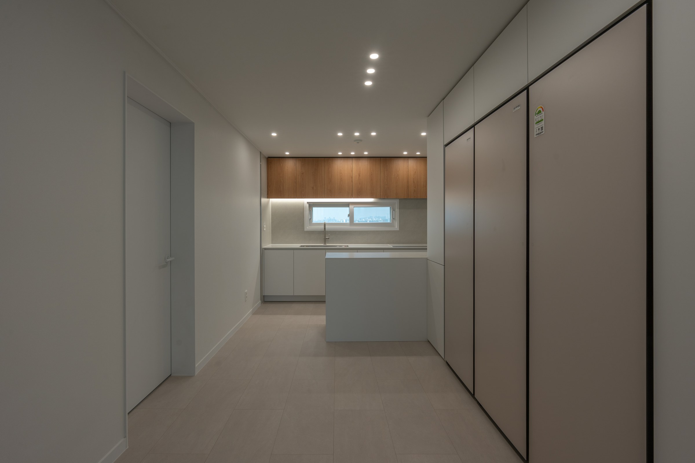 Entrance storage and kitchen connected along a single axis