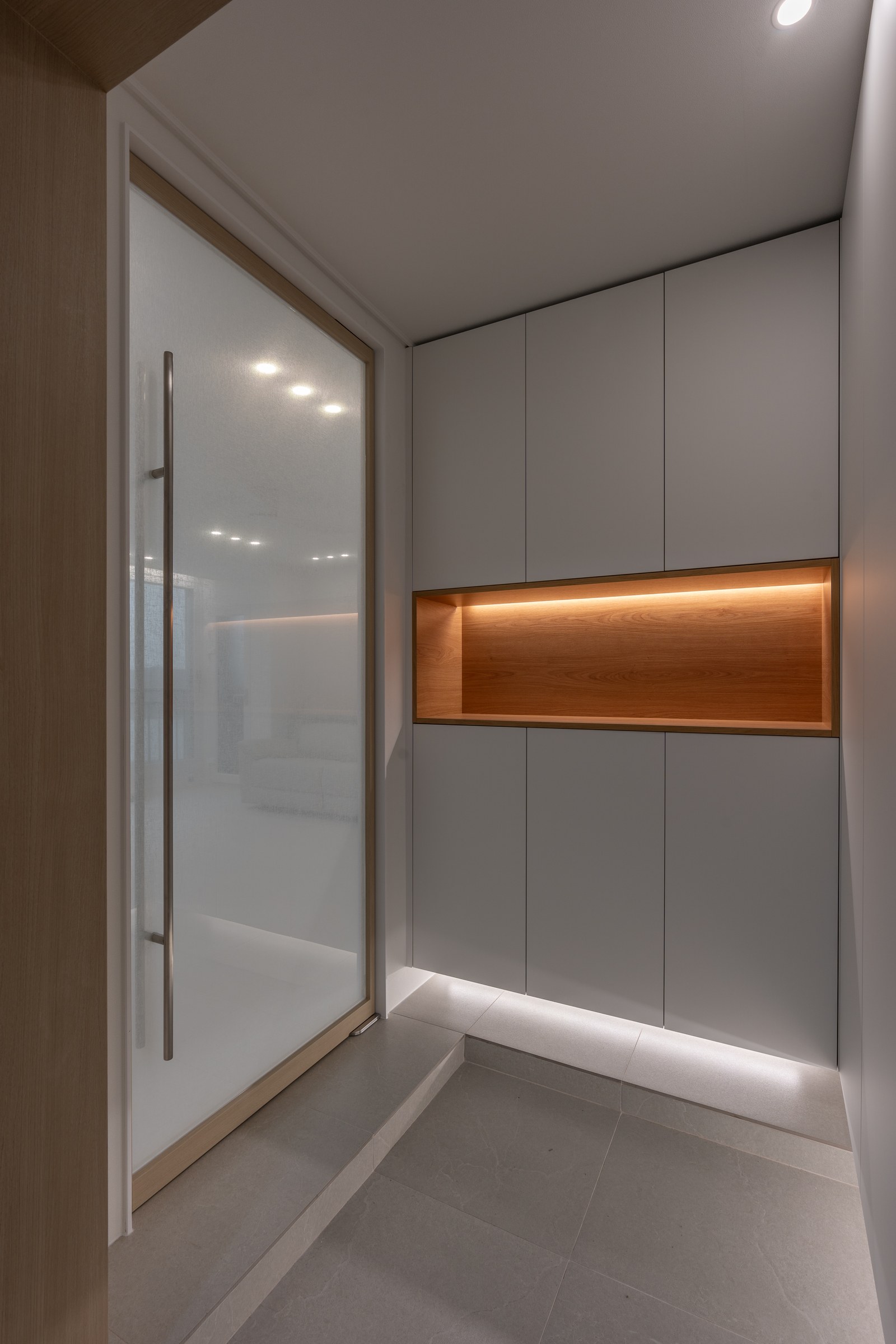 Timber-lit niche set into the grey entrance storage wall